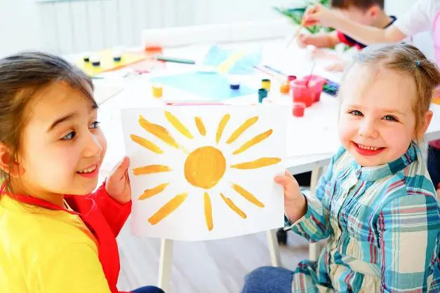 Two children holding up a sun picture